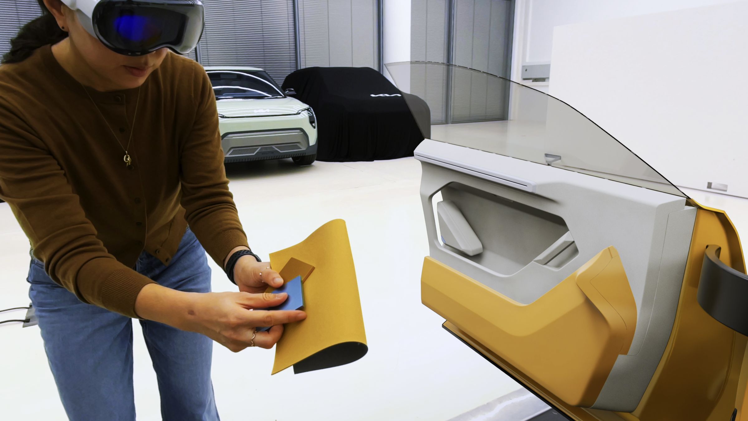 Designer in Vision Pro comparing a yellow material swatch against a vehicle door panel.