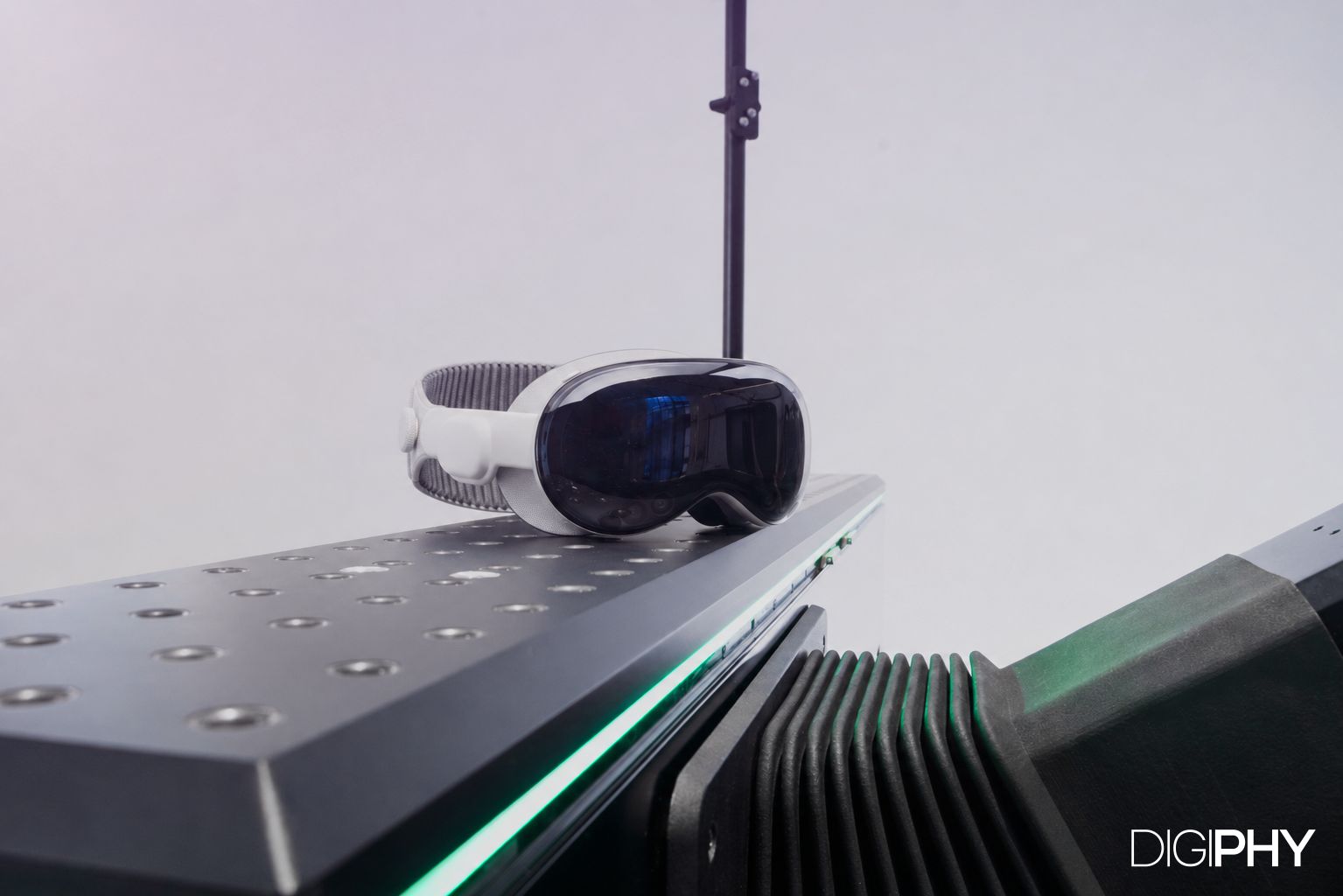 Apple Vision Pro headset resting on the DIGIPHY dynamic seating buck by Granstudio, with green LED lighting and mechanical actuators visible