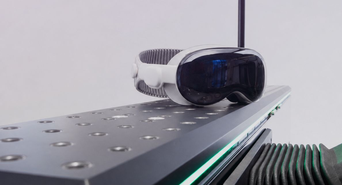 Apple Vision Pro headset resting on the DIGIPHY dynamic seating buck by Granstudio, with green LED lighting and mechanical actuators visible